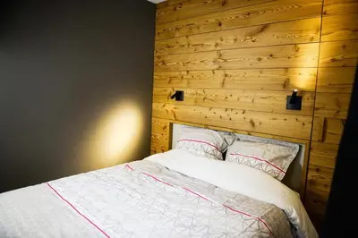 a bedroom with a bed with a wooden headboard at La Chabane in Chamonix-Mont-Blanc