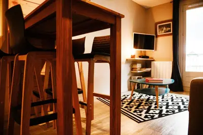 a room with a bunk bed with a table and a couch at La Chabane in Chamonix-Mont-Blanc