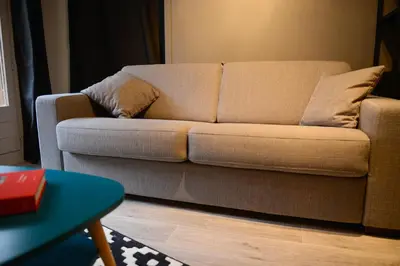 a brown couch in a living room with a table at La Chabane in Chamonix-Mont-Blanc