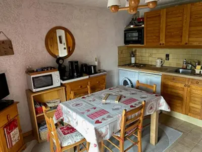 a kitchen with a table with chairs and a sink at La Coupe De Cristal in Saint-Gervais-les-Bains