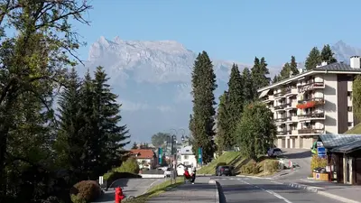 a street in a town with a mountain in the background at La Coupe De Cristal in Saint-Gervais-les-Bains