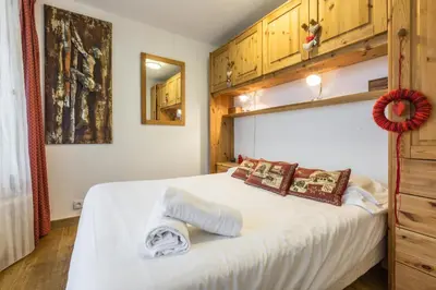 a bedroom with a large white bed with wooden cabinets at Apartment Mummery 1 - Central Chamonix Walk to Piste in Chamonix-Mont-Blanc