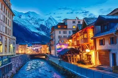 a river in a city with mountains in the background at Apartment Mummery 1 - Central Chamonix Walk to Piste in Chamonix-Mont-Blanc