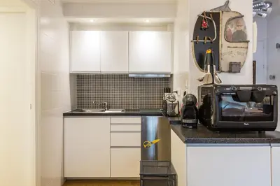 a kitchen with white cabinets and a sink at Apartment Mummery 1 - Central Chamonix Walk to Piste in Chamonix-Mont-Blanc