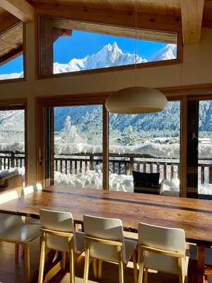 a dining room with a table and chairs and a mountain view at Marmotte Mountain Eco Lodge in Chamonix-Mont-Blanc