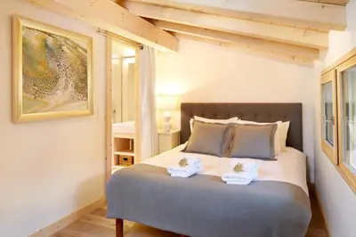 a bedroom with a bed with two towels on it at Marmotte Mountain Eco Lodge in Chamonix-Mont-Blanc