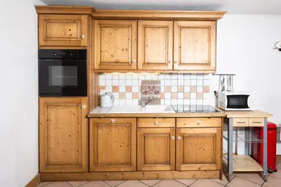 a kitchen with wooden cabinets and a sink at Ginabelle 8 apartment - Chamonix All Year in Chamonix-Mont-Blanc