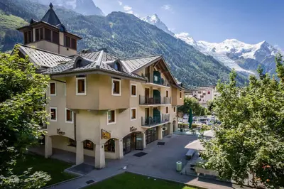 a large building with mountains in the background at Ginabelle 8 apartment - Chamonix All Year in Chamonix-Mont-Blanc