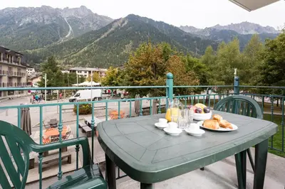 a table with a plate of food on a balcony at Ginabelle 8 apartment - Chamonix All Year in Chamonix-Mont-Blanc