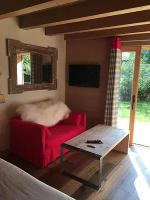 a living room with a red couch and a table at Chalet Mine de rien in Megève