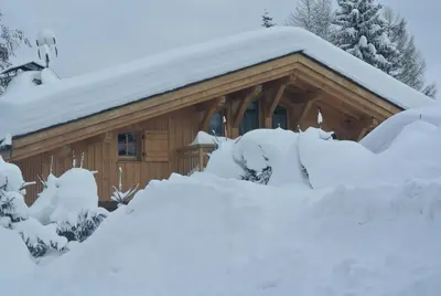a log cabin with snow on the roof at Chalet Mine de rien in Megève