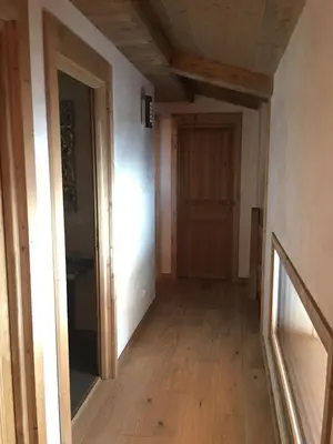 a hallway with a wooden floor and a door at Les Chalets Aquarelle in Chamonix-Mont-Blanc