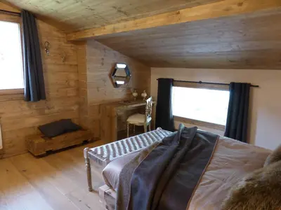 a bedroom with wooden walls and a bed and a window at Les Chalets Aquarelle in Chamonix-Mont-Blanc