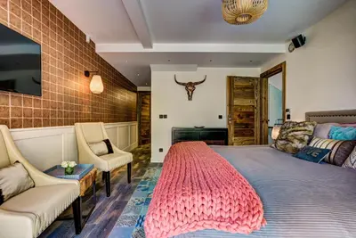 a bedroom with a large bed with a pink rug at Peace and Love in Chamonix-Mont-Blanc