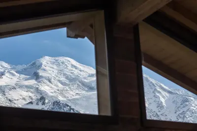a view of a snow covered mountain through a window at Peace and Love in Chamonix-Mont-Blanc