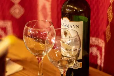 two wine glasses sitting next to a bottle of wine at Chalet Alpine Rose in Chamonix-Mont-Blanc