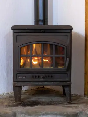 a black stove with a fire inside of it at Chalet Alpine Rose in Chamonix-Mont-Blanc