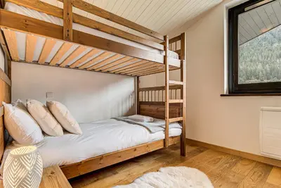 a bedroom with two bunk beds and a window at APARTMENT LES DRUS - Alpes Travel - Chamonix - Sleeps 6 in Chamonix-Mont-Blanc