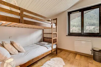 a bedroom with two bunk beds and a window at APARTMENT LES DRUS - Alpes Travel - Chamonix - Sleeps 6 in Chamonix-Mont-Blanc