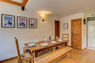 a dining room with a wooden table and chairs at APARTMENT CHAMOUNY - Alpes Travel - Chamonix - Sleeps 8 in Chamonix-Mont-Blanc