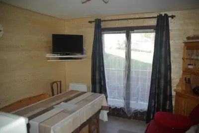 a room with a table and a window with a television at appart st gervais le Topaze in Saint-Gervais-les-Bains