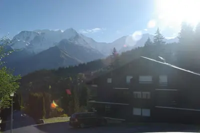 a house with a car parked in front of a mountain at appart st gervais le Topaze in Saint-Gervais-les-Bains