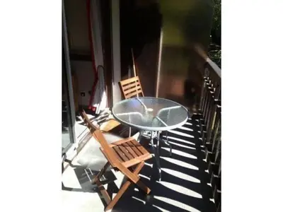 a glass table and two chairs on a balcony at Apartment Clos du Savoy in Chamonix-Mont-Blanc
