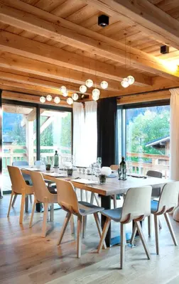 a dining room with a large wooden table and chairs at Chalet spacieux à Samoëns de 210 m² avec jacuzzi et jardin in Samoëns
