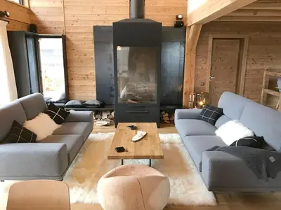 a living room with two couches and a table at Chalet spacieux à Samoëns de 210 m² avec jacuzzi et jardin in Samoëns