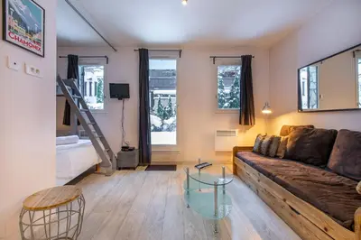 a living room with a couch and a glass table at Studio Aoste in Chamonix-Mont-Blanc