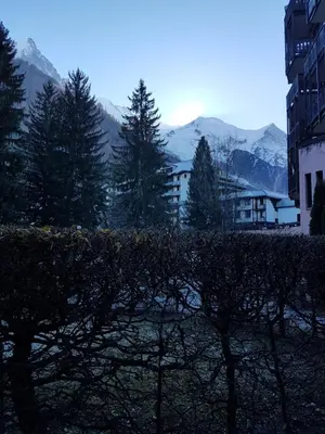 a view of a building and trees and mountains at Studio Aoste in Chamonix-Mont-Blanc
