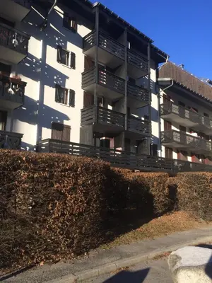 an apartment building with a hedge in front of it at Studio Aoste in Chamonix-Mont-Blanc
