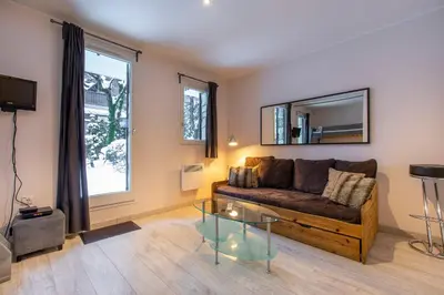 a living room with a couch and a glass table at Studio Aoste in Chamonix-Mont-Blanc