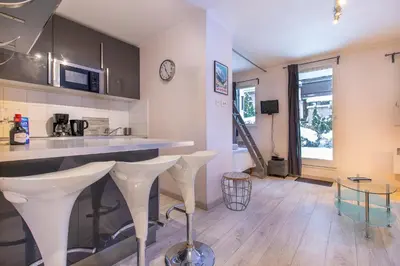 a kitchen with a counter and stools in a room at Studio Aoste in Chamonix-Mont-Blanc