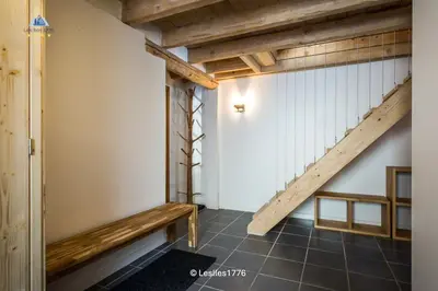 a hallway with a wooden staircase and a bench at Les Iles 1776 in Chamonix-Mont-Blanc