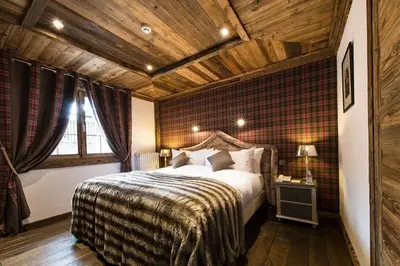 a bedroom with a large bed and a wooden ceiling at Le Chalet Blanc in Megève