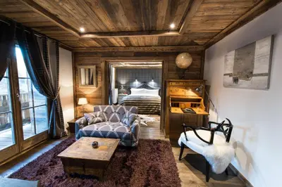 a living room with a couch and a bed at Le Chalet Blanc in Megève
