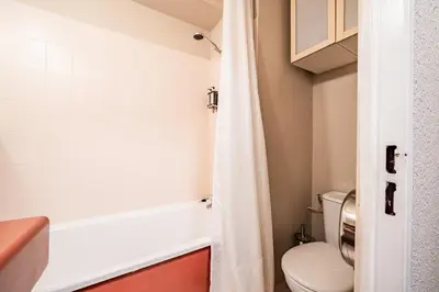 a small bathroom with a toilet and a bathtub at Eden Studio Chamonix Centre in Chamonix-Mont-Blanc