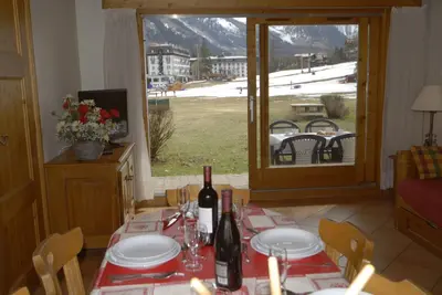 a dining room with a table with glasses and wine bottles at Front Ski Slope Chamonix Apartment in Chamonix-Mont-Blanc