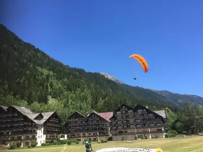 a person flying a kite in front of a hotel at Front Ski Slope Chamonix Apartment in Chamonix-Mont-Blanc