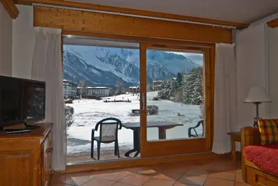 a room with a window with a view of a snowy mountain at Front Ski Slope Chamonix Apartment in Chamonix-Mont-Blanc