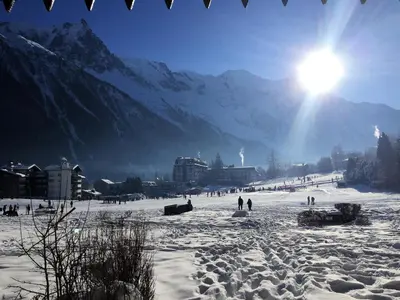 a group of people standing in the snow with the sun at Front Ski Slope Chamonix Apartment in Chamonix-Mont-Blanc