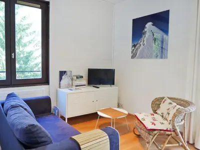 a living room with a blue couch and a chair at Apartment Le Cristal des Glaces by Interhome in Chamonix-Mont-Blanc