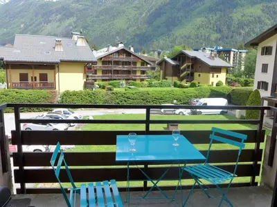 a blue table and chairs on a balcony with a mountain at Apartment Le Cristal des Glaces by Interhome in Chamonix-Mont-Blanc