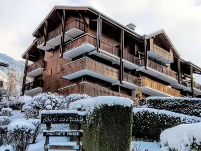 a town with cars parked in a parking lot with mountains at Studio La pointe des Aravis 3 by Interhome in Saint-Gervais-les-Bains