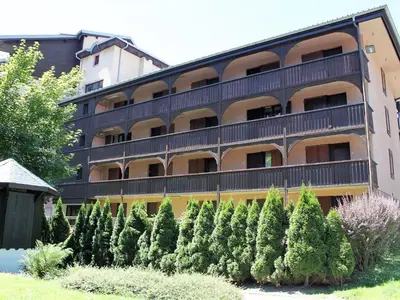an apartment building with trees in front of it at Apartment Jonquille Terrasse Centre Chamonix Mont Blanc in Chamonix-Mont-Blanc