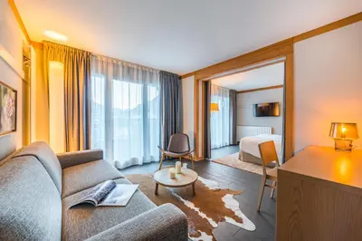 a living room with a couch and a bed at Hotel Le Morgane in Chamonix-Mont-Blanc