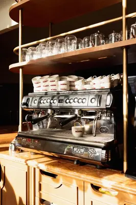 a stove in a kitchen with dishes on a shelf at Hôtel Les Aiglons Chamonix in Chamonix-Mont-Blanc