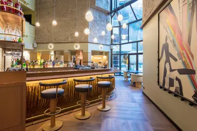 a bar in a restaurant with bar stools at Hôtel Les Aiglons Chamonix in Chamonix-Mont-Blanc