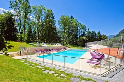 a swimming pool with purple lounge chairs next to at La Grange De L'Aiguille in Chamonix-Mont-Blanc